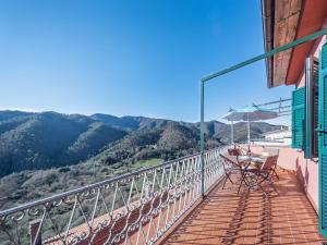 卡罗达诺英弗雷Alpi Apuane Panoramic Apartment的阳台配有桌子和雨伞,享有山景。