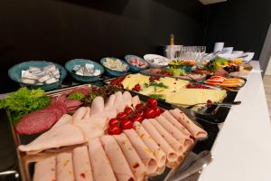 吕讷堡多美洛老百货酒店的自助餐,包括肉类和其他食物在餐桌上
