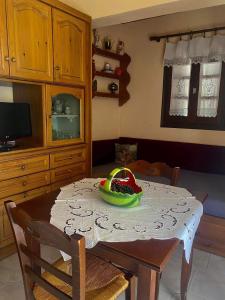 马克里尼撒Διαμέρισμα Αγγελική的厨房配有一张桌子,上面放着一碗水果
