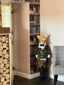 莫法特Cosy country cottage in rural location的一只塞满了狐狸站在书架前