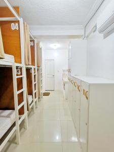 马尼拉NomadsMNL Hostel的宿舍间设有双层床和走廊。