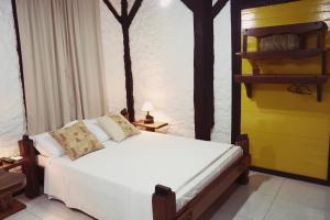 布卢梅瑙Sítio Urbano a apenas 1,5 km do centro的卧室配有白色的床和黄色的墙壁