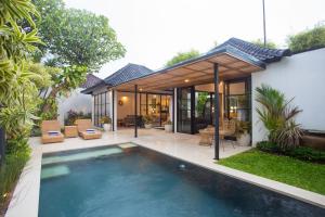 塞米亚克The Kon's Villa Bali Seminyak的一座房子后院的游泳池