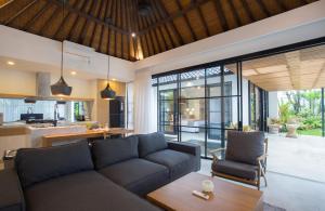 塞米亚克The Kon's Villa Bali Seminyak的客厅配有沙发和桌子