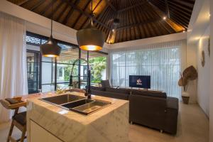 塞米亚克The Kon's Villa Bali Seminyak的厨房以及带沙发和桌子的客厅。