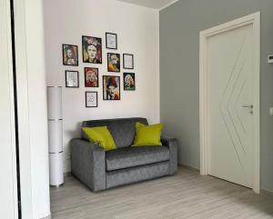 奇维塔韦基亚Simply House Civitavecchia的客厅配有灰色椅子和墙上的照片