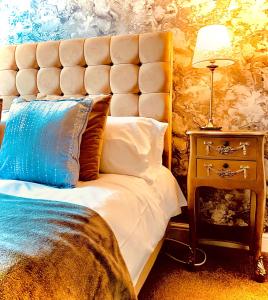 杰德堡The Capon Tree Town House的一间卧室配有一张特大号床和蓝色枕头