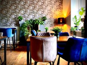 杰德堡The Capon Tree Town House的一间带木桌和蓝色椅子的用餐室