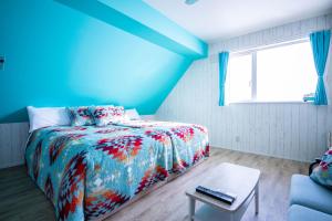 比布Yadoya YADOKARI的蓝色卧室,配有床和桌子