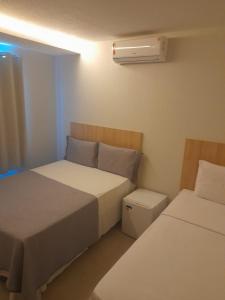 BalsasHOTEL RIOS - BALSAS的一间小卧室,配有两张床和空调