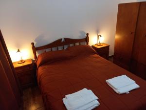 梅洛El Piscui House的一间卧室配有一张床,上面有两条毛巾