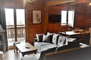 德沃吕伊Grand chalet en bois avec vue splendide的客厅配有沙发和桌子