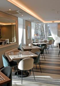 帕兰加Grand Baltic Dunes的餐厅设有桌椅和大窗户。