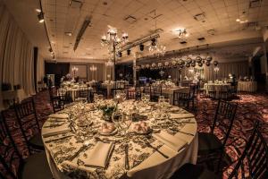 福尔摩沙Howard Johnson Hotel & Casino的一个带长桌、盘子和玻璃的大宴会厅