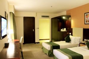 利雅德Business Inn Olaya的酒店客房设有两张床和一台平面电视。