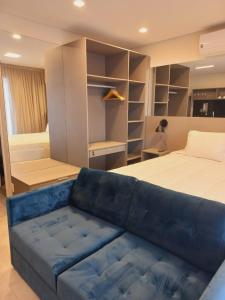 圣保罗Cityhome Platina Tatuapé的一间卧室配有一张床和一张蓝色的沙发