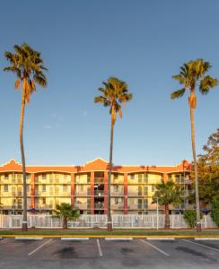 奥兰多Developer Inn Downtown Orlando, a Baymont by Wyndham的停车场前方的棕榈树建筑
