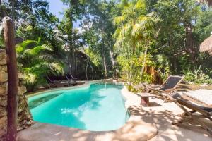 ChemuyilVerdeAmar Eco Lodge Jungle Retreat的一个带长凳和椅子的游泳池