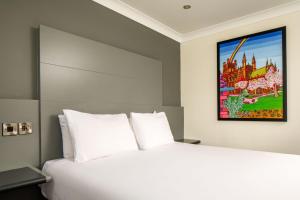 切斯特切斯特艾伯特威尔美居酒店的卧室配有白色的床和墙上的绘画作品