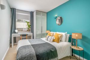 伦敦2 bedroom apartment with park views Shoreditch的一间卧室设有一张床和蓝色的墙壁