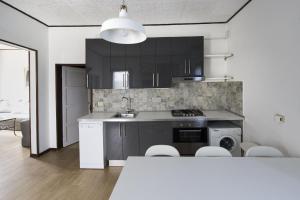 卡奥莱Casa Sincielli的厨房配有黑色橱柜、水槽和炉灶。