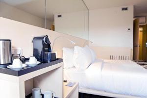 瓦隆古波尔图瓦隆古公园酒店的一间卧室配有一张床,在柜台上配有咖啡壶
