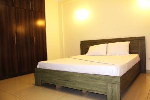 MatolaMatola View Residence的一间卧室配有一张带白色床单的木床