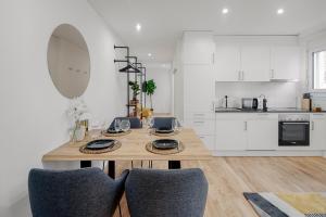 圣加仑EH Apartments Jupiter的白色的厨房配有木桌和椅子