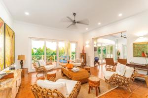 西湾Blue Roatan Resort的客厅配有白色家具和吊扇