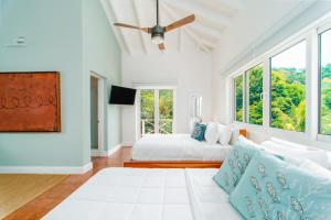 西湾Blue Roatan Resort的白色的卧室设有床和大窗户