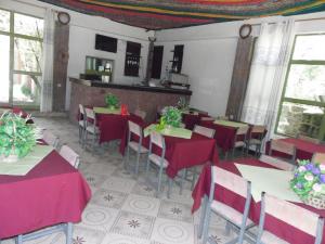 拉利贝拉拉利贝拉酒店的餐厅配有桌椅和红色桌布