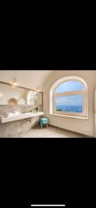 卡普里VILLA OLGA LUXURY CAPRI的一间卧室设有一张床和一个海景窗户