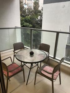 拉马特甘Family Apartment By IsrApart的阳台配有一张桌子和四把椅子