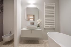 威尼斯Ninfea Luxury Suites的白色的浴室设有水槽和浴缸。