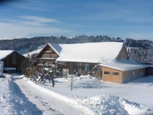 HembergFerienhof-Barenegg的雪覆盖的谷仓,有雪覆盖的道路