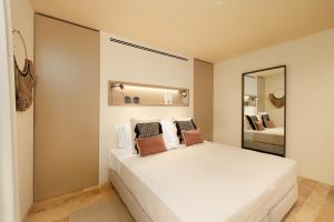 拉戈斯Palmares Signature Apartments的卧室配有带枕头的大型白色床