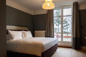 巴塞尔Boutique Hotel Waldhaus beider Basel的一间卧室设有一张床和一个大窗户