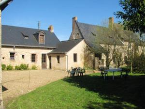 Maison de 5 chambres avec jardin clos et wifi a Morannes sur Sarthe的前面有两张野餐桌的房子