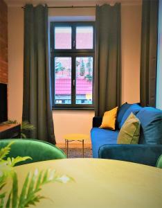 卢巴瓦新城Central LOFT的客厅设有蓝色的沙发和窗户。