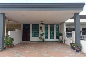 怡保Sweet 3 bedroom home @ Canning Garden, Ipoh的一座带绿色百叶窗的房屋的前廊