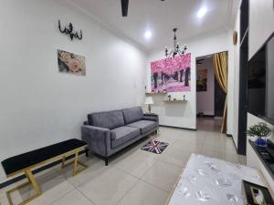 怡保Sweet 3 bedroom home @ Canning Garden, Ipoh的客厅配有沙发和桌子