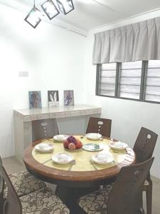 怡保Sweet 3 bedroom home @ Canning Garden, Ipoh的餐桌、椅子和桌子,上面有水果