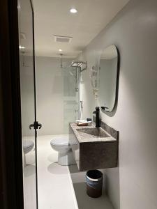 利雅德Land walk Hotel的一间带水槽、卫生间和镜子的浴室