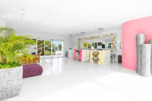 女人岛女人岛米娅礁坎昆度假酒店的一间设有粉色和紫色家具和镜子的客房