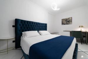 那不勒斯Apartments Hotel Real Suite Napoli Chiaia Mergellina的一间卧室配有一张大床和蓝色床头板