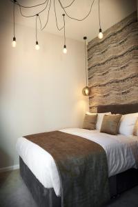 利物浦Home @ 2 Tancred Road的一间卧室设有一张带石墙的大床