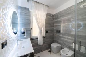 那不勒斯Apartments Hotel Real Suite Napoli Chiaia Mergellina的一间带水槽、卫生间和镜子的浴室