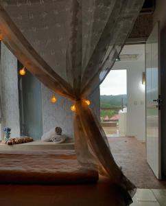 巴拉奈里奥-坎布里乌Estaleiro Casa Hotel的一间卧室配有一张带天蓬和窗户的床