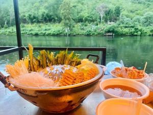 Ban Tha Thong Mon河山边度假村 的河边的桌子上放着一碗胡萝卜