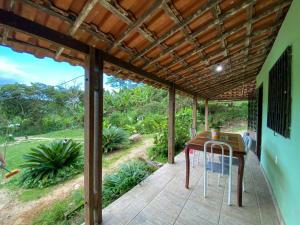 瓜拉米兰加Casa no Sítio的庭院配有木桌和椅子。